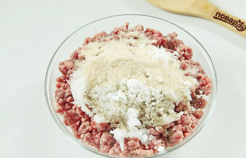 1. Этап. Зразы мясные с морковью: Добавьте измельченный репчатый лук, крахмал, столовую ложку сухарей и соль по вкусу.