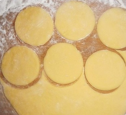 1. Этап. Творожное тесто для вареников на пару: 5. Творожное тесто для вареников на пару в домашних условиях должно быть мягким (поэтому добавляйте муку постепенно). Раскатайте его и с помощью выемок сделайте кружочки. Их размер зависит от выбранной начинки и ваших вкусовых предпочтений.