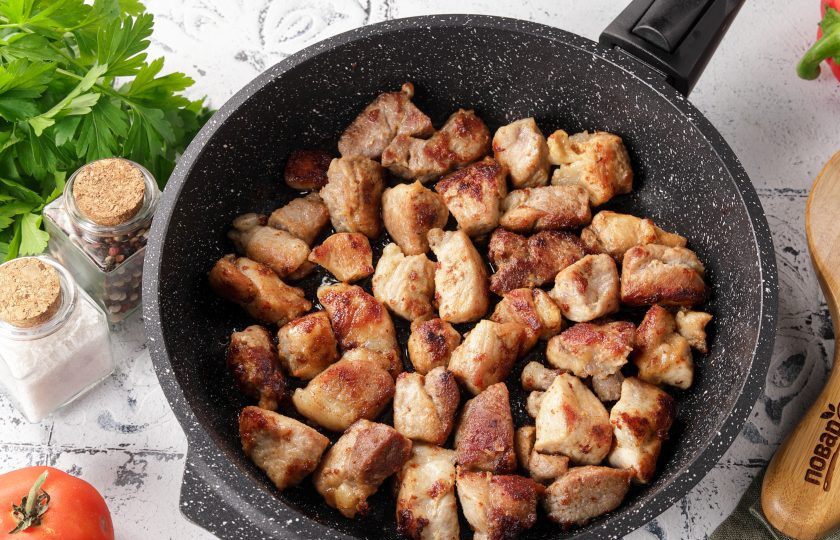 1. Этап. Мясо по-сербски: В сковороде разогрейте половину порции растительного масла и обжарьте мясо до лёгкой румяной корочки.