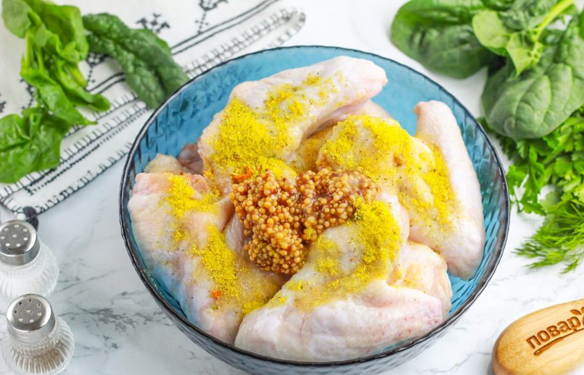 1. Этап. Крылышки в медово-горчичном соусе в духовке: Выложите их в глубокую емкость и добавьте цветочный мед, горчицу, приправу куриную и соль. По желанию добавьте немного молотого черного перца или другие пряности, но не крупного помола. Тщательно перемешайте и оставьте на 1 час мариноваться при комнатной температуре.