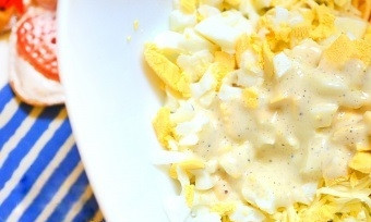 1. Этап. Сырный салат с яйцом: 3. Сильно охлажденное сливочное масло (можно положить его минут на 15 в морозилку) натрите на мелкой тёрке. Также добавьте его к салату. Посолите по вкусу и перемешайте. Заправьте майонезом, предварительно смешав его с черным молотым перцем. Сырный салат с яйцом готов! Приятного аппетита!