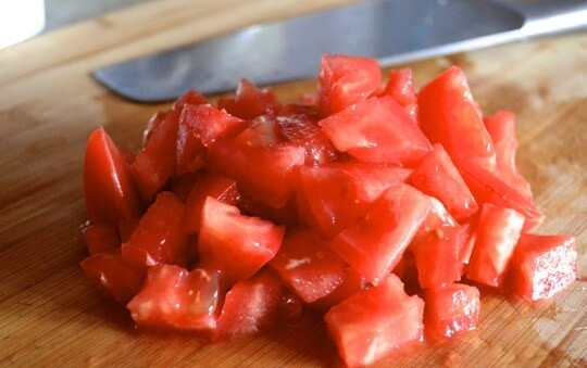 1. Этап. Паэлья с курицей и горошком: 4. Добавьте предварительно помытый и нарезанный помидор, готовьте в течение 1 минуты.