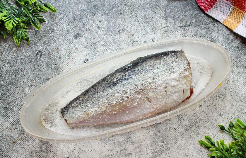 1. Этап. Сельдь специального посола: Возьмите половину соли, посыпьте немного дно посуды, где будете солить селедку. Остальную соль вотрите внутрь и снаружи. Выложите рыбу в посуду.