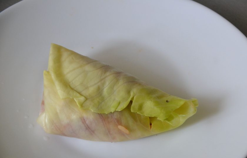 1. Этап. Голубцы по-цыгански: Выложите фарш на капустный лист, сверните в виде треугольного кулечка, подвернув верх капустного листа внутрь.