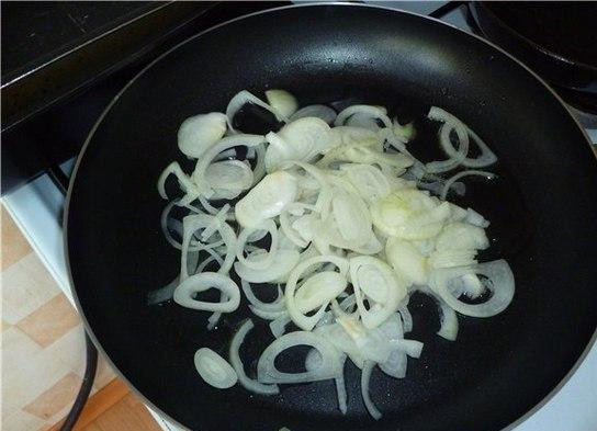 1. Этап. Рагу по-мексикански: Репчатый лук нарезаем полукольцами. В сковороде разогреваем растительное масло, бросаем туда нарезанный лук и 3-4 минуты обжариваем на медленном огне.