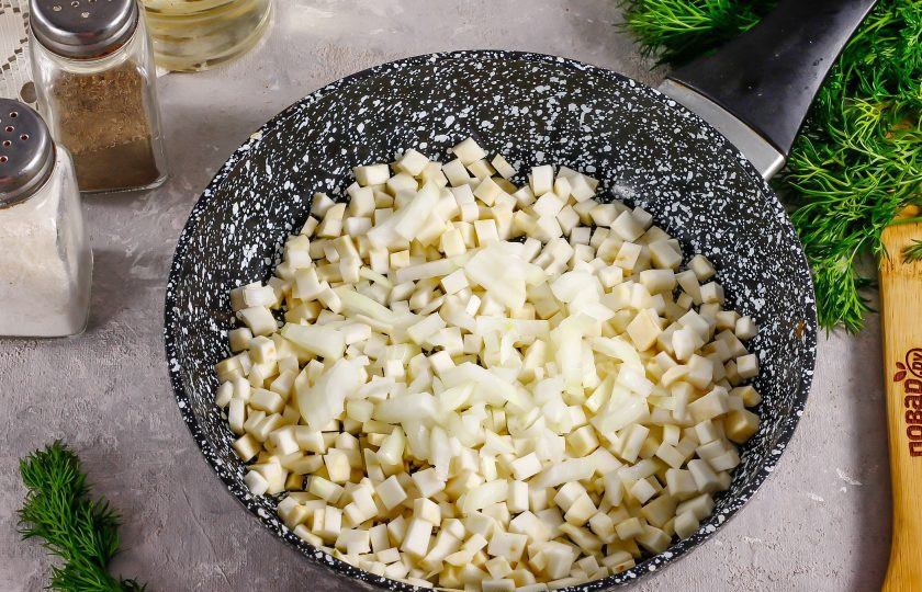 1. Этап. Говяжьи щечки с ризотто из сельдерея: Очистите половину корня сельдерея от кожуры, промойте и нарежьте мелкими кубиками. Точно так же нарежьте очищенный и промытый лук. Прогрейте на сковороде растительное масло и высыпьте в него обе овощные нарезки.