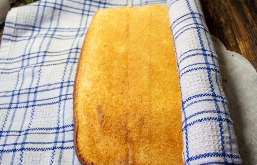 1. Этап. Рулет Рафаэлло: Накройте его полотенцем, переверните и снимите аккуратно пергамент. Сверните в рулет вместе с полотенцем. Оставьте остыть минут на 15-20.