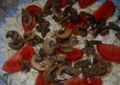 1. Этап. Cалат из куриного филе с шампиньонами: Сверху раскладываем нарезанные на небольшие дольки помидоры и потом кладем остывшие жареные шампиньоны.