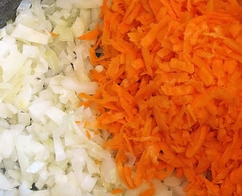 1. Этап. Долма с рисом: Жарим в казане измельченный лук и тертую морковь.