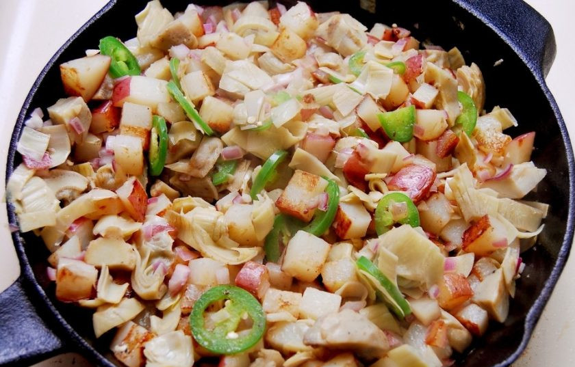 1. Этап. Яичница с артишоками и картофелем: 3. Затем в сковороду добавьте чеснок, репчатый лук и перец. Через минуту всыпьте артишоки. Обжарьте овощи в течение 7 минут.