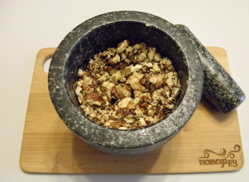 1. Этап. Сладкая колбаска: Грецкие орехи освободите от скорлупы. Подавите их в ступке, только не мелко, чтобы в готовой колбаске были видны кусочки.