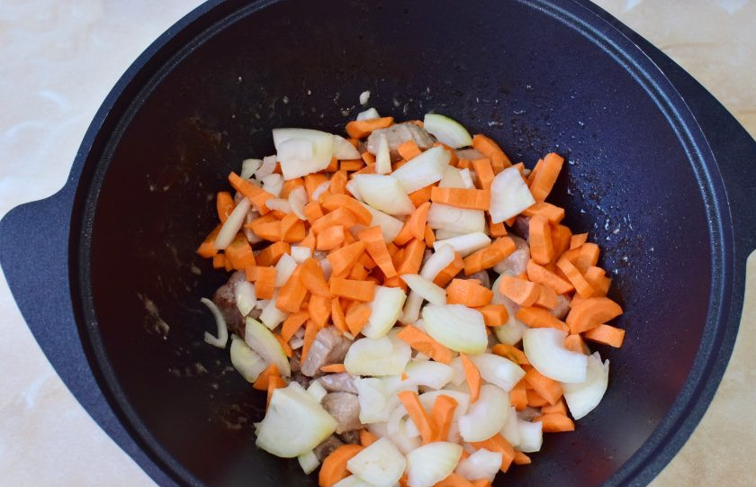 1. Этап. Плов праздничный: Выложите овощи в казан к мясу и оставьте все вместе готовиться еще минут на 10. Большой огонь не делайте, чтобы говядина успела приготовиться.