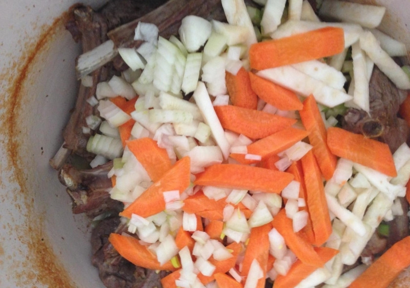 1. Этап. Корейка из баранины: 5. Через отведенное время достаю казан из духовки, перемешиваю мясо и добавляю корень и стебель сельдерея, морковку и лук, а также очищенный чеснок. Ставлю обратно в духовой шкаф на 30 минут.