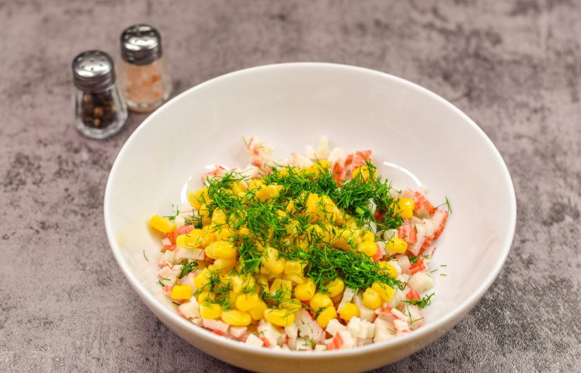 1. Этап. Закуска на чипсах на праздничный стол: Свежий укроп сполосните и просушите, нарежьте мелко и добавьте в салат.