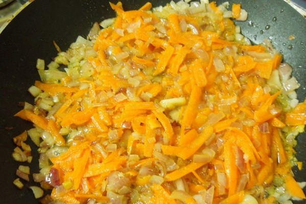 1. Этап. Суп из филе пангасиуса: Добавляем к нему тертую морковку и измельченный чеснок.