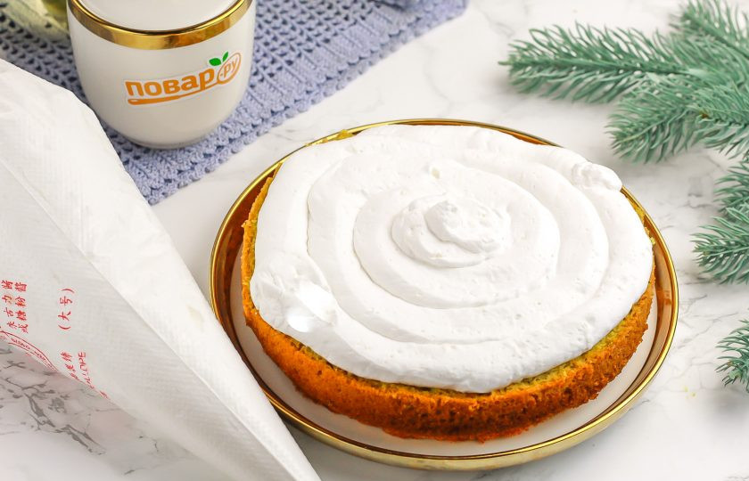 1. Этап. Торт Змея на Новый год: Выложите на блюдо нижний корж. Переместите крем в кондитерский пакет или шприц и отсадите на корж.