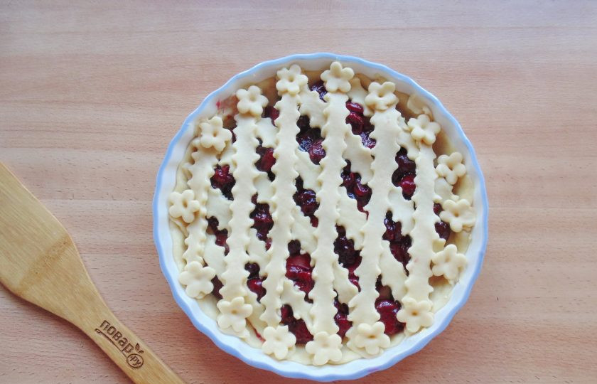 1. Этап. Кростата с вишней: Вторую часть теста раскатайте и нарежьте полосками шириной 1-1,5 сантиметра. Выложите полоски теста на начинку в виде решетки.