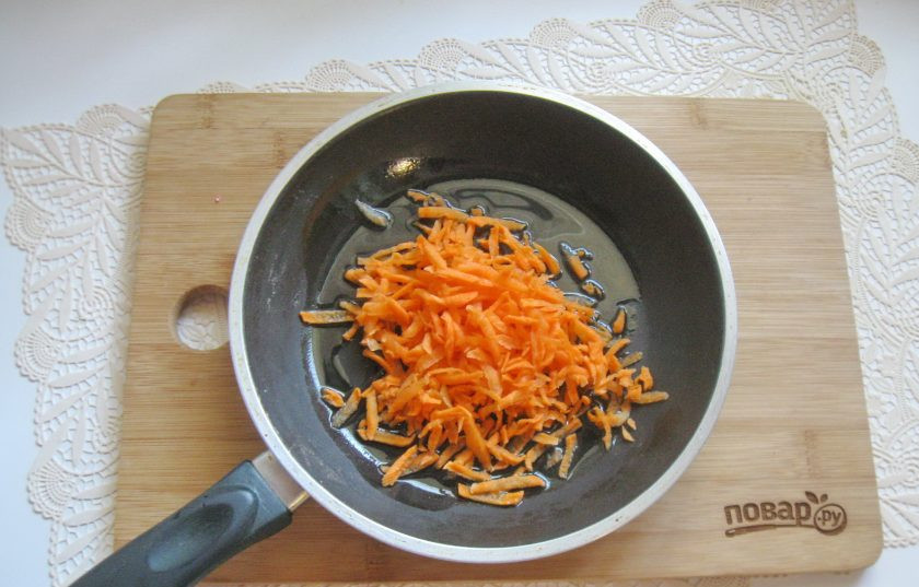 1. Этап. Салат Балтийский: Морковь очистите, помойте и натрите на терке. Выложите в сковороду.