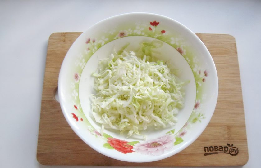 1. Этап. Капуста с чесноком и морковью: Капусту нарежьте тонкой соломкой и немного пожмите руками. Выложите в салатник.