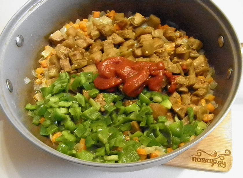 1. Этап. Икра из баклажанов кусочками: К полуготовым луку и моркови добавьте баклажаны, сладкий перец и томатную пасту. Протушите 10-15 минут.