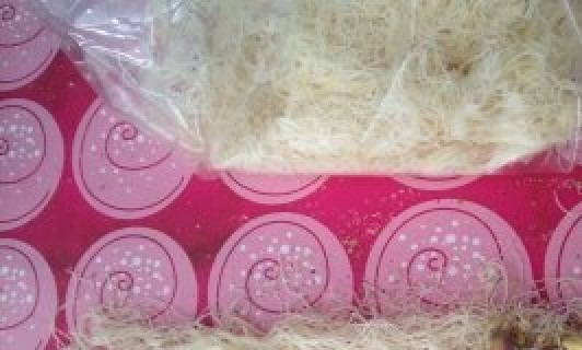 1. Этап. Греческое тесто Катаифи: Тесто разморозьте. Разделите его на части в 3-4 см. шириной. На один конец уложите ореховую начинку. Заверните тесто рулетиком.