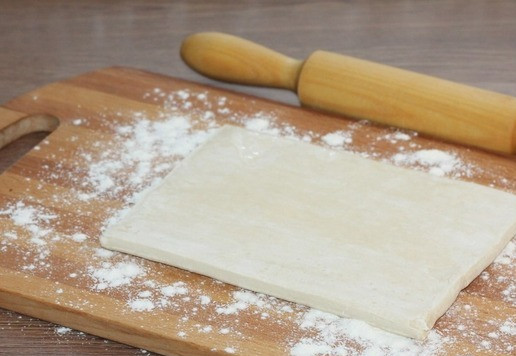 1. Этап. Мини-слойки с тунцом и оливками: 7. Стол и скалку, припылите мукой и выложите тесто.