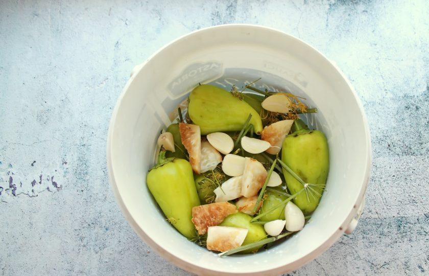 1. Этап. Таркинский перец: Добавьте к перцу очищенный чеснок, веточки укропа и порезанный на дольки корневой сельдерей.