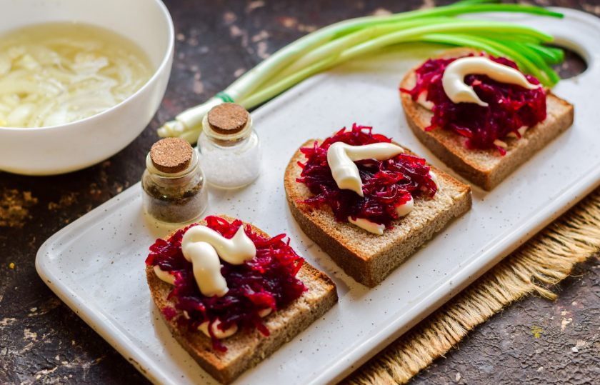 1. Этап. Бутерброды Сельдь под шубой: Свеклу натрите на мелкой терке, выложите поверх хлеба, смажьте майонезом.