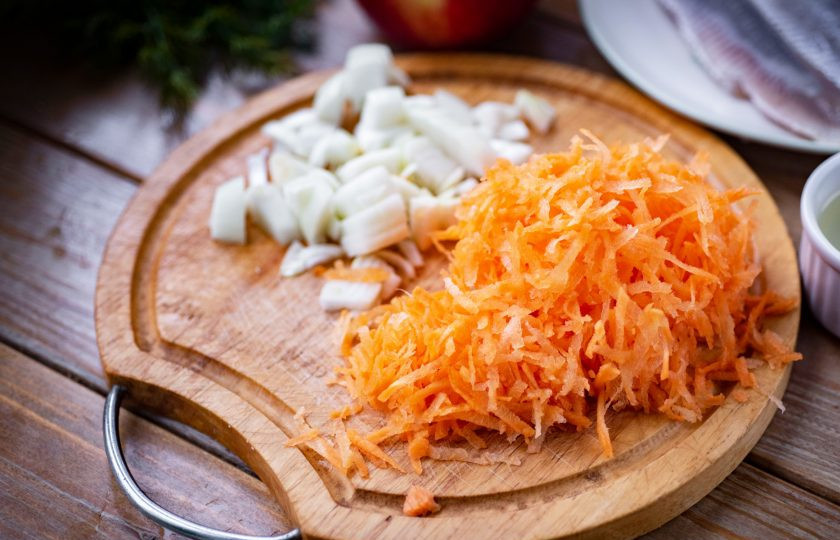 1. Этап. Салат Сельдь под одеялом: Нашинкуйте лук мелкими кубиками, морковь натрите на крупную терку.