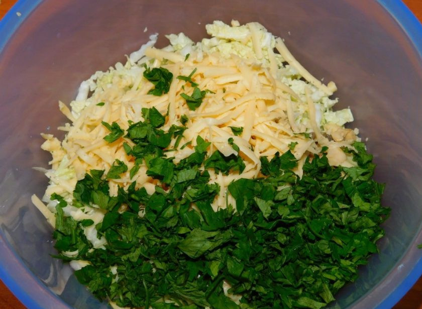 1. Этап. Салат с пекинской капустой и грибами: Добавьте тертый сыр и нарезанную зелень.
