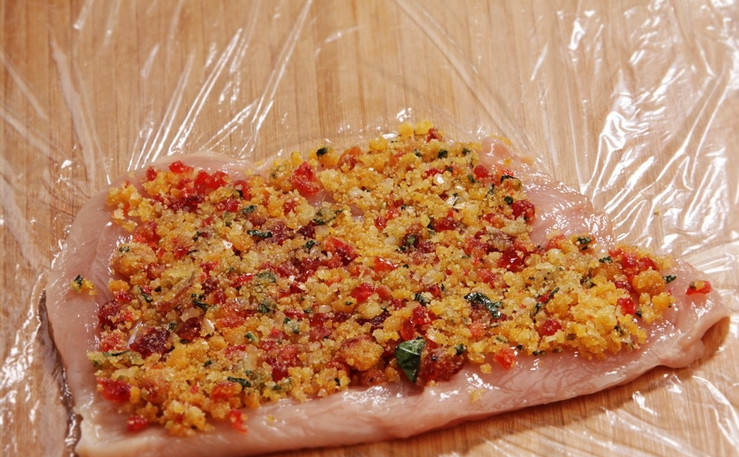 1. Этап. Куриный рулет в пищевой пленке: В куриной грудке делаем надрез ножом, чтобы получился плоский пласт. Выкладываем его на пищевую пленку, сверху распределяем начинку.