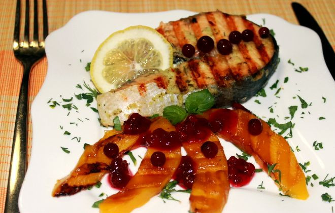 1. Этап. Имбирный лосось с манго-гриль и брусничным соусом: Блюдо посыпать мелко-порубленной зеленью, уложить стейк лосося, манго, полить брусничным соусом, украсить лимоном и ягодками брусники