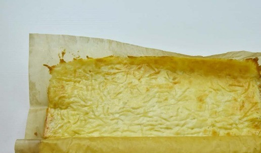 1. Этап. Сырный рулет с индейкой и грибами: Горячий корж извлечь из духовки и свернуть в рулет вместе с пекарской бумагой. Дать ему остыть в течение 5 минут.