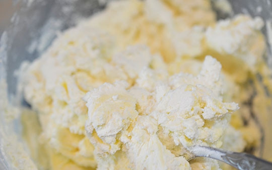 1. Этап. Традиционный рождественский штоллен: Смешайте творог с мягким маслом (100 г), добавьте сахар.