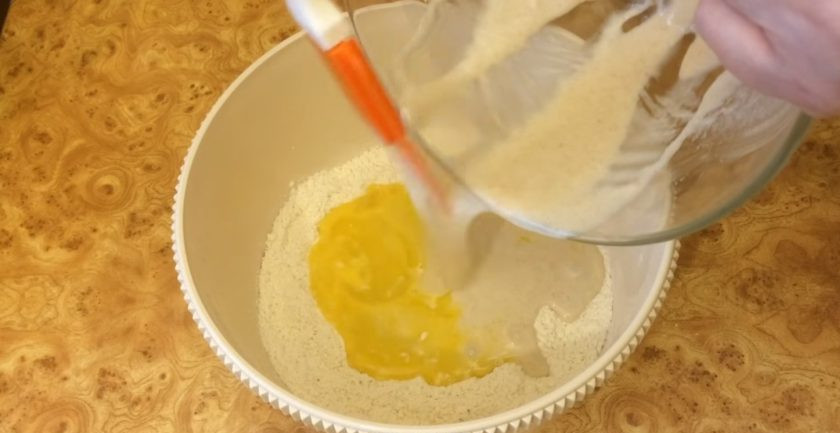 1. Этап. Булочки Улитки с заварным кремом: 2. Добавьте воду комнатной температуры и хорошо перемешайте. В миску выложите просеянную муку, сахар и соль. Сделайте небольшое углубление и выложите туда яйцо. Взболтайте яйцо вилкой и добавьте опару.