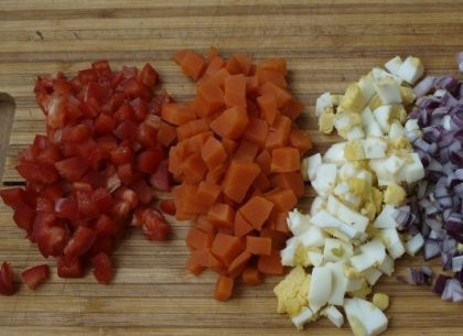 1. Этап. Закуска из сельди к праздничному столу: Яйцо, лук, перец и морковку нарезаем на небольшие кубики. А часть зелени рубим меленько.