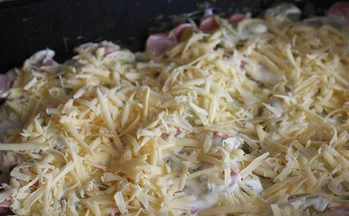 1. Этап. Запеканка с сосиской и картошкой: В чашке смешиваем сметану и майонез, смазываем приготовленной смесью картофель с сосисками, затем обильно посыпаем все тертым на крупной терке сыром.