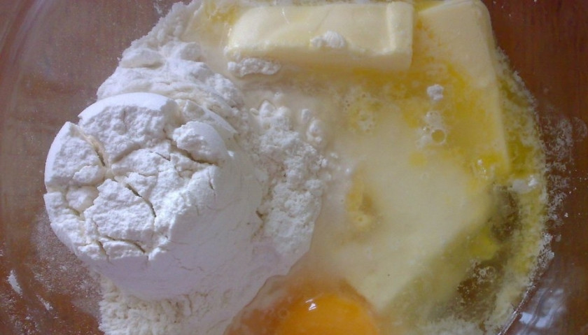 1. Этап. Пирог с курицей и грибами: Первым делом поставьте отвариваться курицу. Затем необходимо замесить тесто. Для этого в большой стеклянной миске смешайте просеянную муку, мягкое сливочное масло, соль, воду, а также сырые куриные яйца. Из всех этих ингредиентов замесите мягкое тесто.