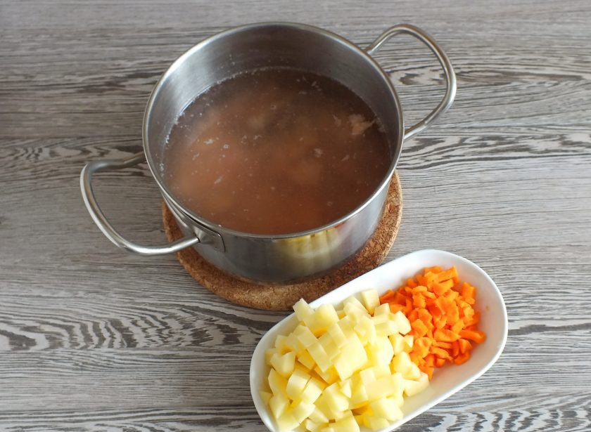 1. Этап. Рыбный суп Калья: В рыбный бульон добавьте рыбу без косточек, нарезанные мелким кубиком картофель и морковь. Поставьте на огонь. Варите до готовности овощей.