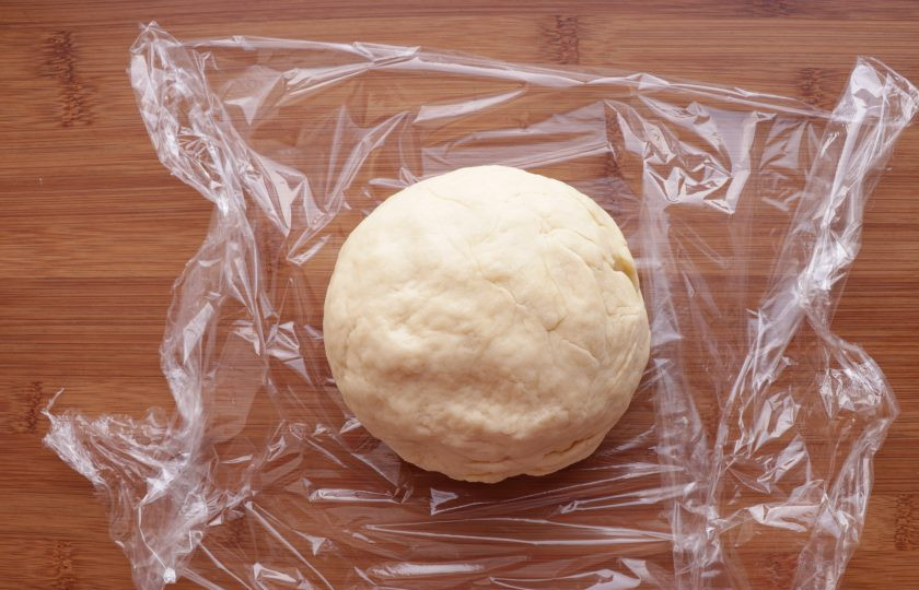 1. Этап. Рогалики с изюмом: Скатайте тесто в шар, заверните в пищевую пленку и оставьте в холодильнике на 1 час.