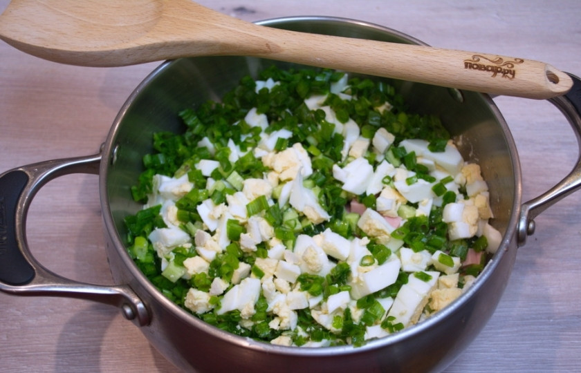 1. Этап. Окрошка классическая: Отварной картофель очистим от шкурки и нарежем кубиком. Картофель, огурцы, колбасу, яйца и зелень поместите в емкость.