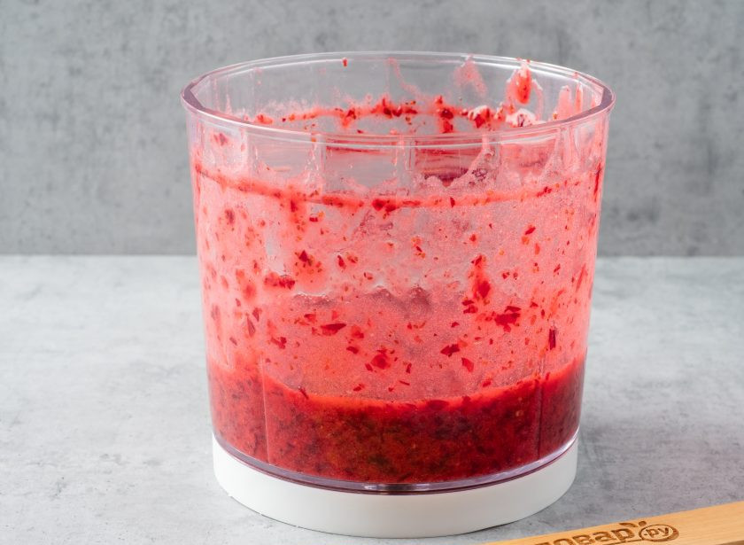 1. Этап. Брусника с сахаром на зиму: Пробейте ягоды блендером или перекрутите через мясорубку.