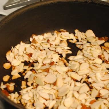 1. Этап. Кускус с миндалем и изюмом: Тем временем миндаль, нарезанный на тонкие пластинки , обжариваем на сухой сковороде. Жарим на среднем огне около 3 минут, постоянно помешивая - чтобы не пригорел.