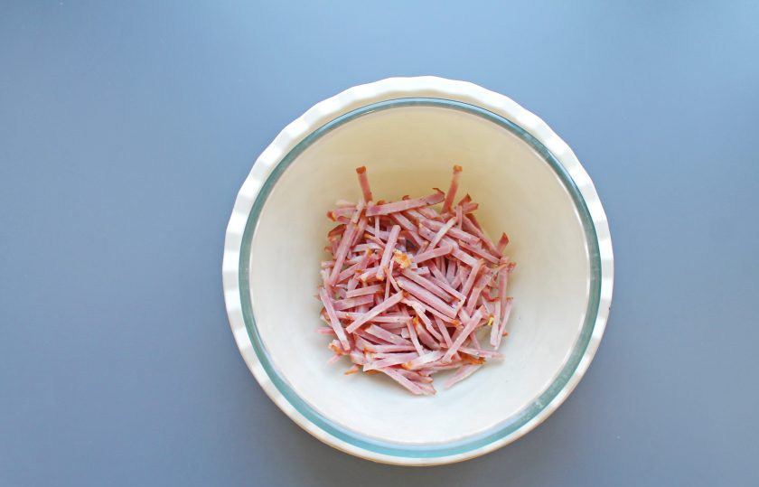 1. Этап. Салат Старый Мюнхен: Копченую колбасу порежьте тонкой соломкой и выложите в салатник.