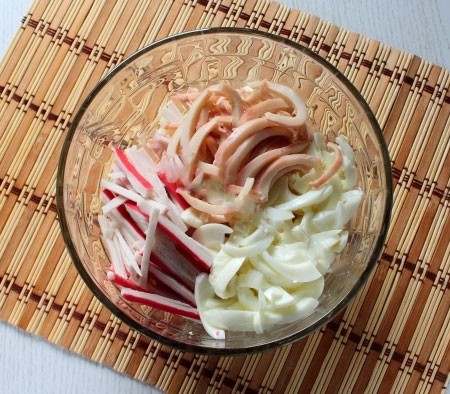 1. Stage. Royal Seafood Salad: Boil squids in boiling, salted water for about half a minute, cool, peel and cut into rings or strips. Add the chopped egg whites and also the chopped crab sticks.