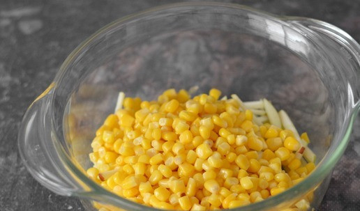 1. Этап. Салат с кальмарами, яблоком и кукурузой: С консервированной кукурузы слейте жидкость и добавьте в миску к яблокам.