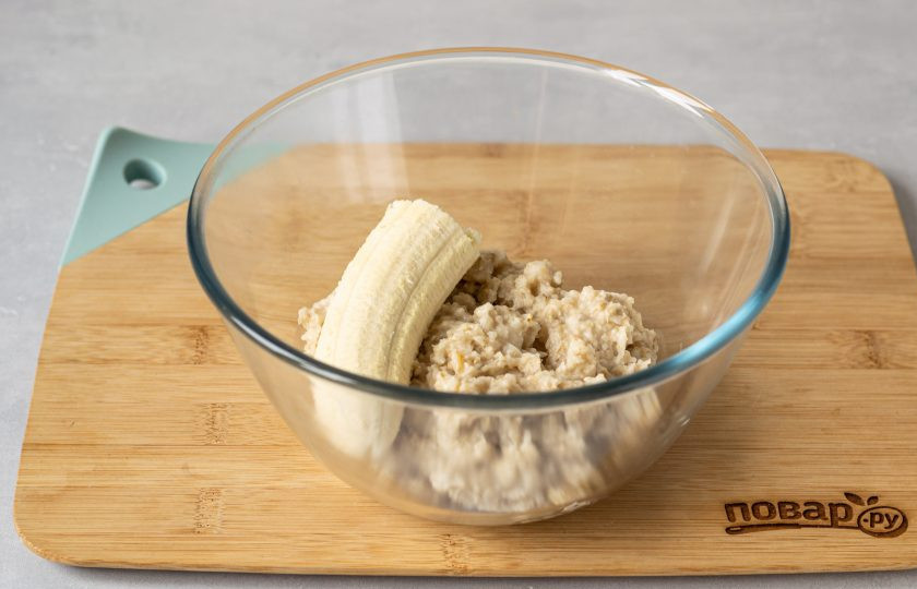 1. Этап. Постные овсяные оладьи: Переложите овсянку в глубокую миску. Добавьте банан и измельчите массу блендером.