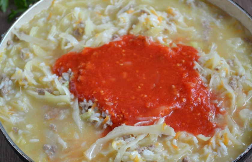 1. Этап. Ленивые голубцы под соусом: Добавьте томатный сок, соль, перец. Можно также положить лавровый лист, немного чеснока. Перемешайте и тушите под крышкой до мягкости всех ингредиентов.