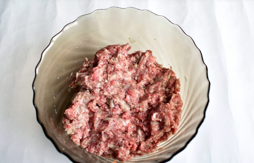 1. Этап. Штрули: Для начинки нашинкуйте мелко репчатый лук, присолите его и хорошенько промните руками до образования сока. Смешайте лук с фаршем, посолите и поперчите по вкусу. Хорошо вымешайте фарш.