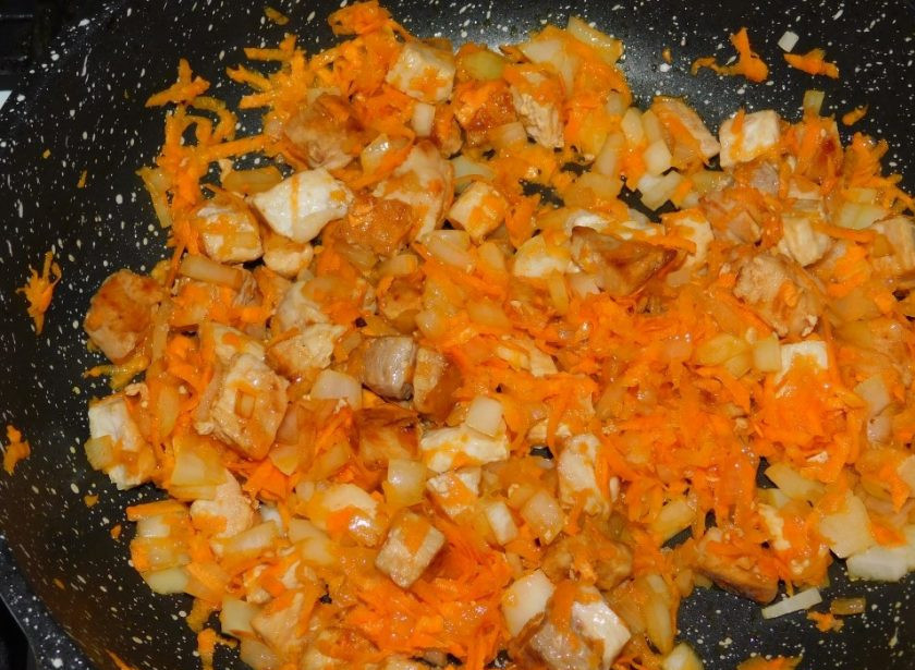 1. Этап. Свинина с куриной печенью и базиликом: Добавьте тертую морковь и мелко нарезанный лук. Продолжайте жарить все вместе ещё несколько минут. Затем на небольшом огне доведите мясо до готовности.